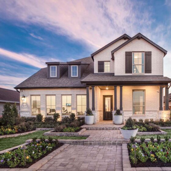 A pink sunset sets against a blue sky with a Highland homes model home at VIDA San Antonio.