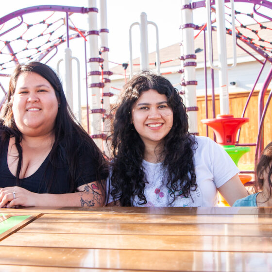 a family sits down in Ana Park at VIDA San Antonio