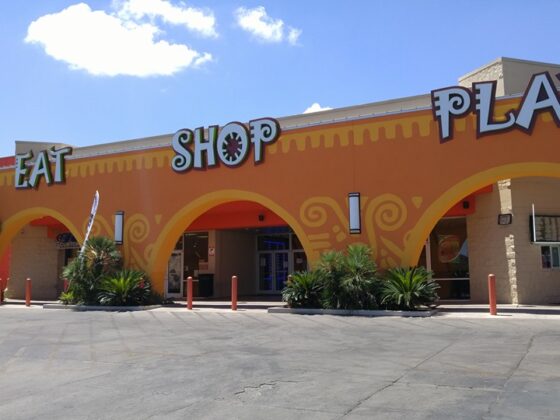 A vibrant shopping plaza against a sunny sky