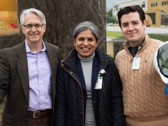 Three notable attendees at a University Health VIDA Clinic groundbreaking hold shovels and hard hats and smile