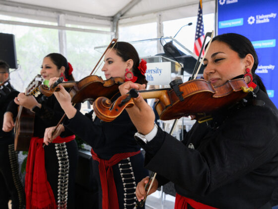 A group of four mariachi play instruments at a University Health event