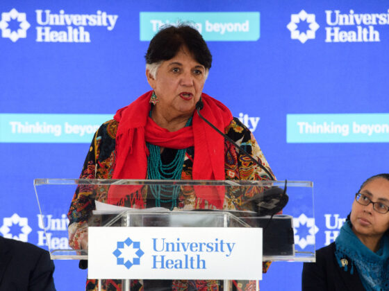 A speaker stands at a podium during a University Health event