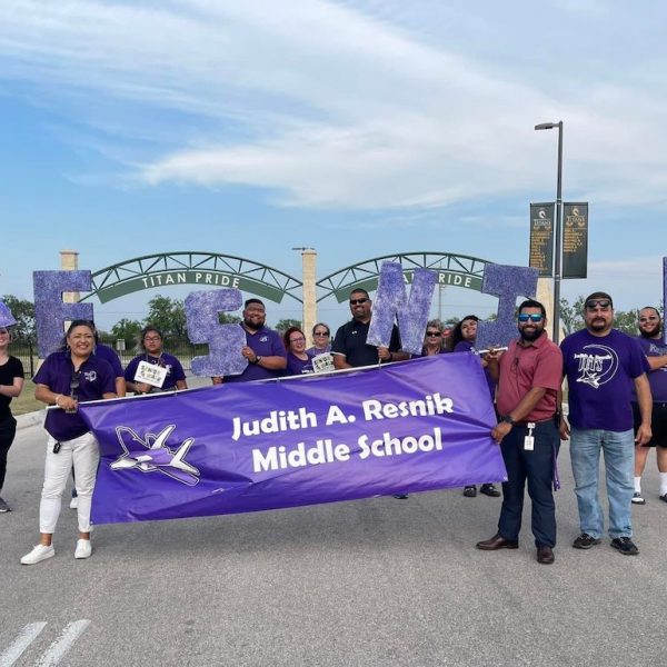 Staff from Judith A. Resnik Middle School hold a school banner