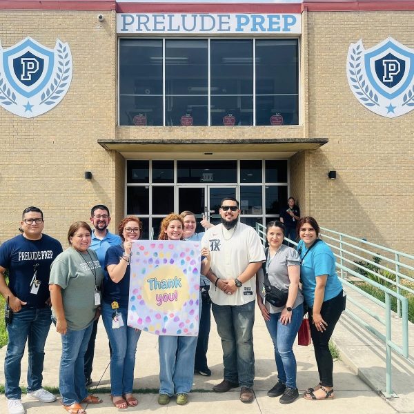 Students, staff and educators hold a "thank you" banner in front of Prelude Prep School