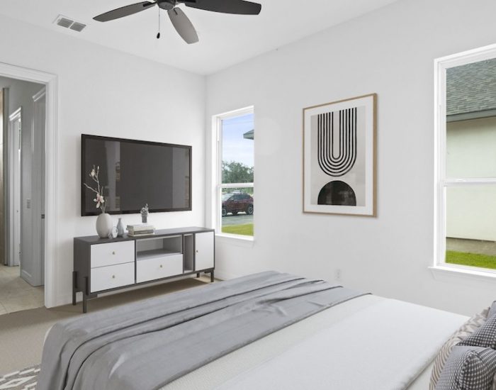 A modern Sitterle townhomes bedroom with abstract art on the walls and a bed with gray bedding.