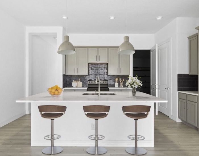 A sleek, modern townhome kitchen with a kitchen island and bar stools.