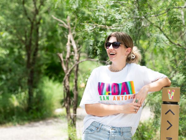 A bright smile from a young woman as she leans on a trail marker on the Madla Greenway